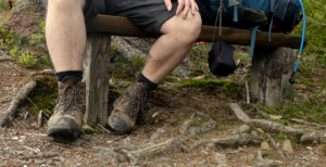 Füße in Wanderschuhen bei einer Pause – Blasen beim Wandern vermeiden